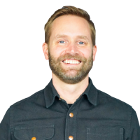 Mike head and shoulders, with blonde hair, beard, and black dress shirt