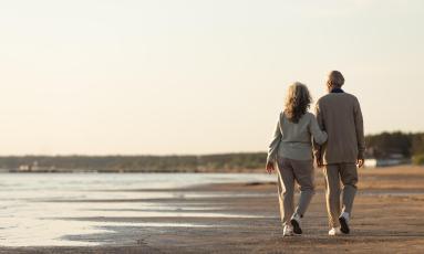 Senior couple walking along shoreline
